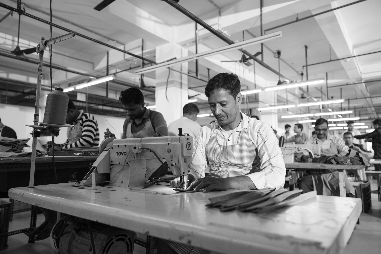 Black and white photograph of leather artisans at the Raja & Mitsu factory in Kolkata